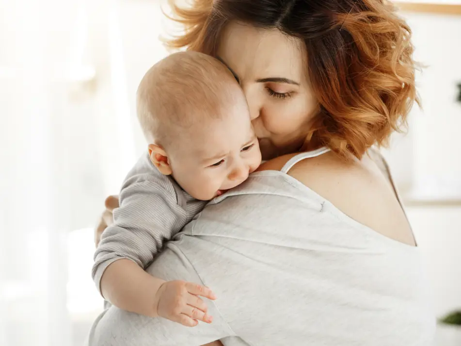 Crying baby being soothed by mum demonstrating calming techniques and understanding baby cues